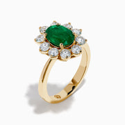 The 14K Yellow Gold Natural Emerald and Diamond Lady Di Ring showcases an oval emerald center surrounded by a halo of round white diamonds.