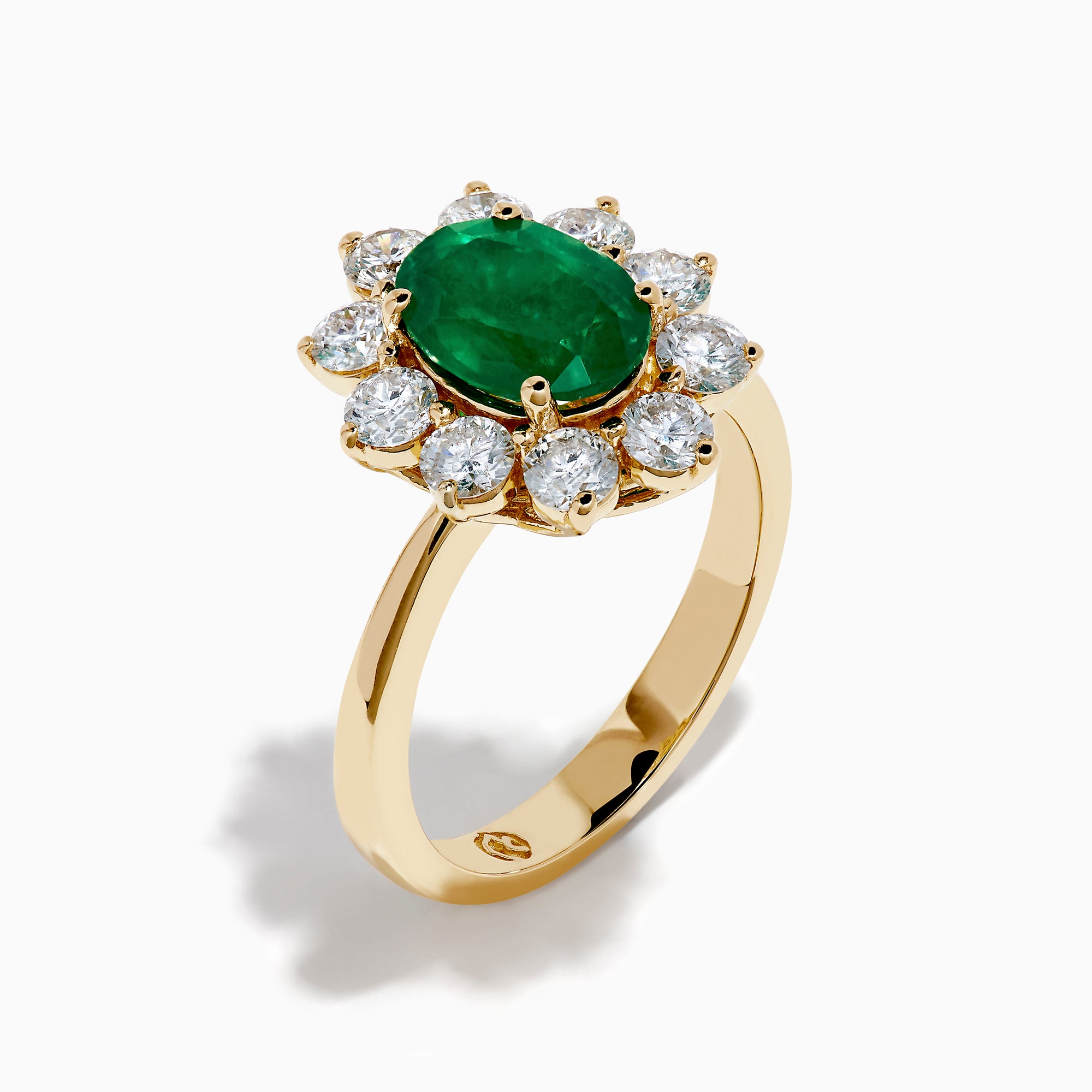 The 14K Yellow Gold Natural Emerald and Diamond Lady Di Ring showcases an oval emerald center surrounded by a halo of round white diamonds.