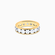 The 14K Yellow Gold Channel Set Diamond Eternity Band, 4.00 TCW, showcases large round diamonds in a continuous channel setting around the band, elegantly displayed on a white background.