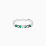 The 14K White Gold 7-Stone Emerald & Diamond Band, 0.25 TCW, showcases alternating round emeralds and diamonds set in a row along the band, displayed on a plain white background.