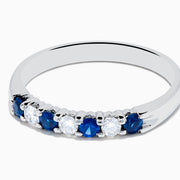 The 14K White Gold 7-Stone Blue Sapphire & Diamond Band (0.50 TCW) features alternating blue sapphires and diamonds set in a row, shown on a white background.