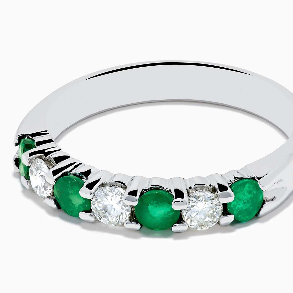The 14K White Gold 7-Stone Emerald & Diamond Band (0.65 TCW) features alternating round emerald and diamond gemstones set in a row, displayed against a white background.