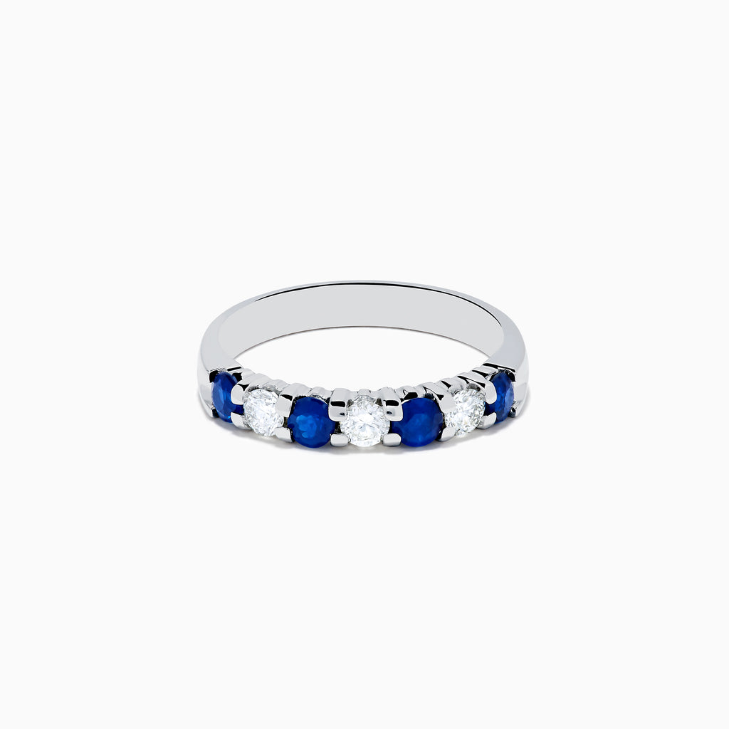 The 14K White Gold 7-Stone Blue Sapphire & Diamond Band, 0.65 TCW, features alternating round blue sapphires and sparkling white diamonds in a row on the band, shown against a white background.