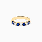 The 14K Yellow Gold 7-Stone Blue Sapphire & Diamond Band, 0.65 TCW, features alternating round blue sapphires and white diamonds set in a row along the band.