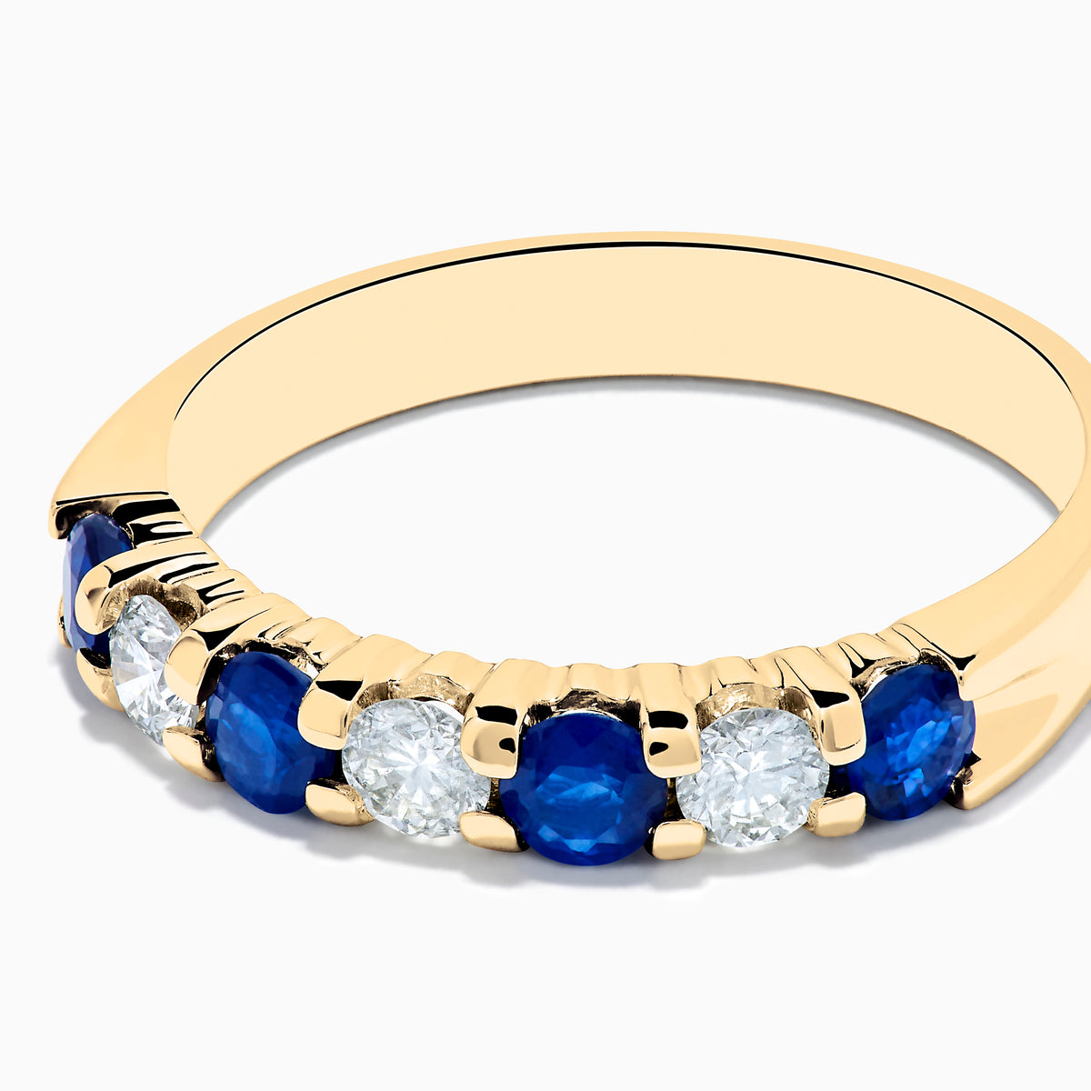 The 14K Yellow Gold 7-Stone Blue Sapphire & Diamond Band, 0.65 TCW, features alternating round blue sapphires and white diamonds set in a row along the band.