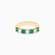 The 14K Yellow Gold 7-Stone Emerald & Diamond Band, 1.00 TCW, features alternating round white diamonds and vibrant emeralds set in a row, shown against a plain white background.
