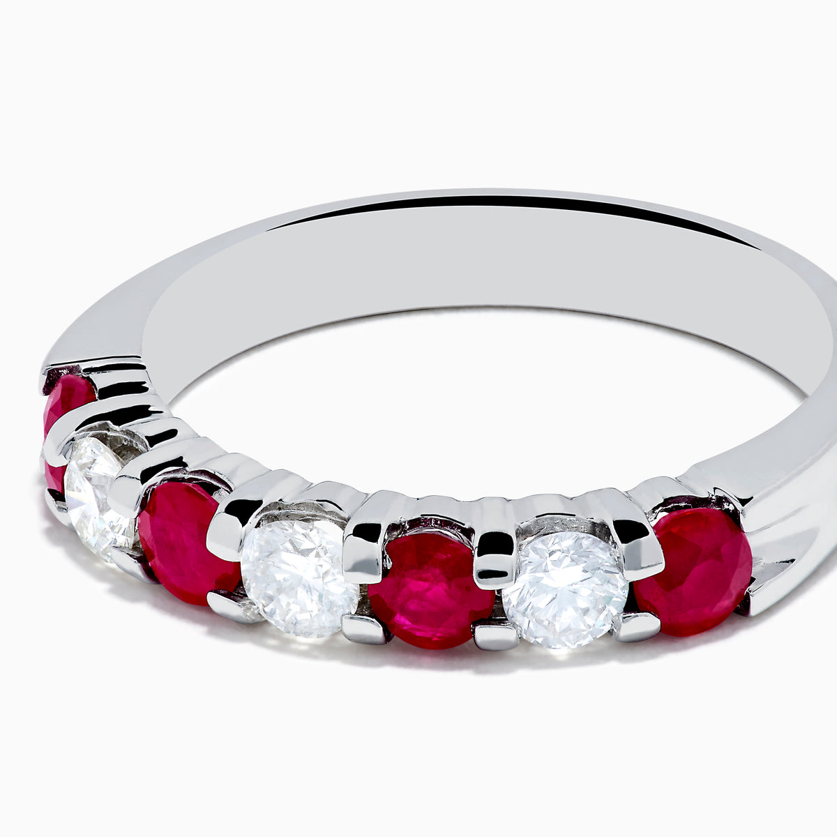 The 14K White Gold 7-Stone Ruby & Diamond Band, 1.00 TCW, showcases alternating round rubies and clear diamonds in a single row along the band, displayed on a white background.