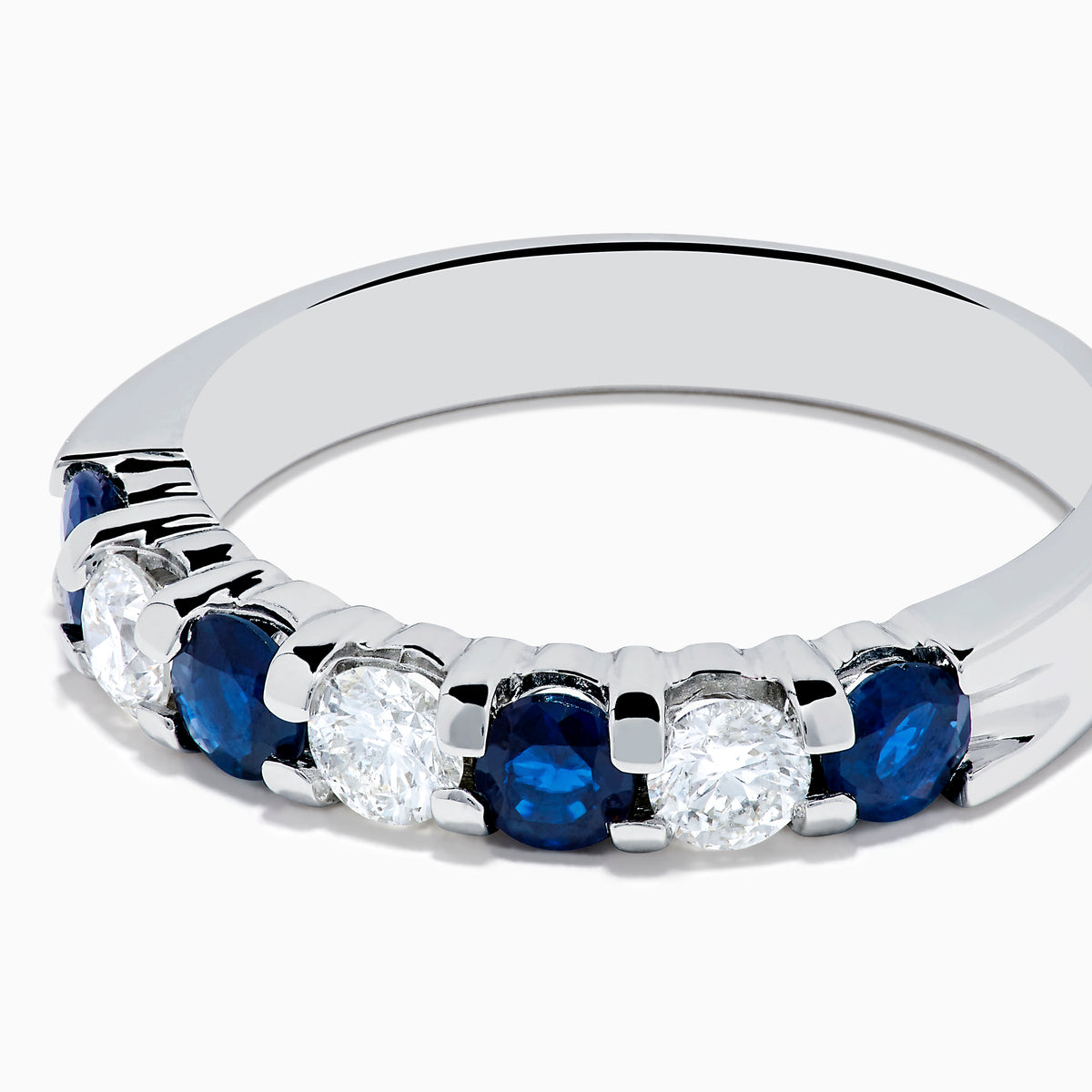 The 14K White Gold 7-Stone Blue Sapphire & Diamond Band, 1.00 TCW, features alternating round blue sapphires and white diamonds, displayed on a plain white background.