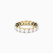The 14K Yellow Gold Prong Set Diamond Eternity Band, 5.00 TCW, features a continuous row of round prong-set diamonds encircling the band, shown against a white background.