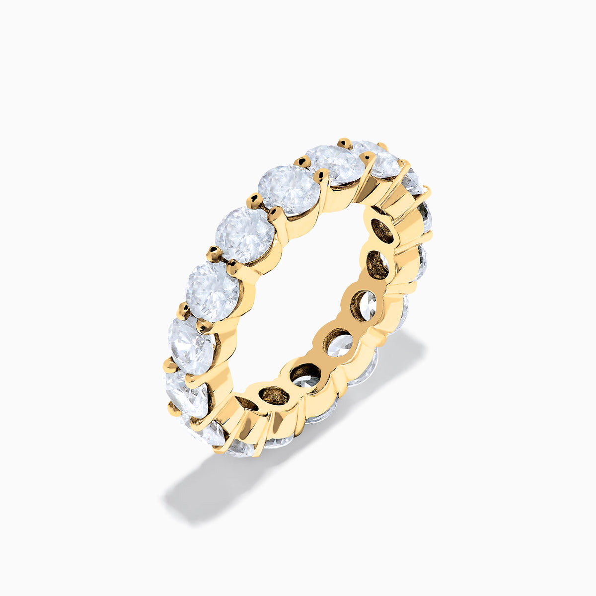 The 14K Yellow Gold Prong Set Diamond Eternity Band, 5.00 TCW, features a continuous row of round prong-set diamonds encircling the band, shown against a white background.