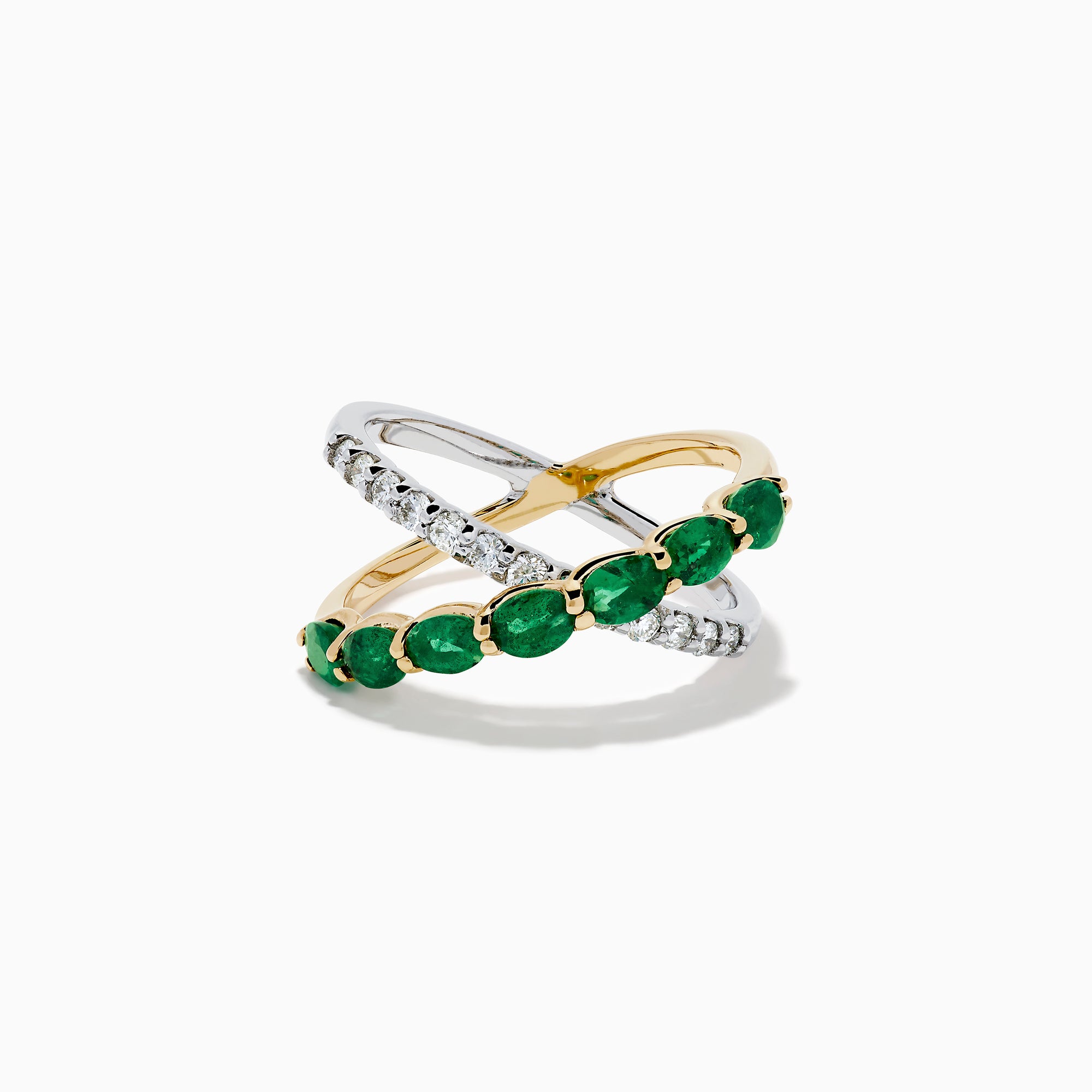 The 14K Two Tone Gold Emerald and Diamond Criss Cross Ring features intertwined yellow gold with green emeralds and white gold with clear round diamonds for a striking, modern look.
