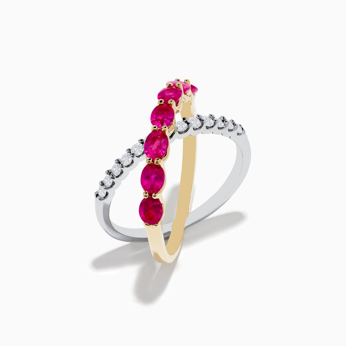The 14K Two Tone Gold Ruby and Diamond Criss Cross Ring features intersecting gold and silver bands—one set with round diamonds, the other with oval rubies—for a strikingly elegant look.