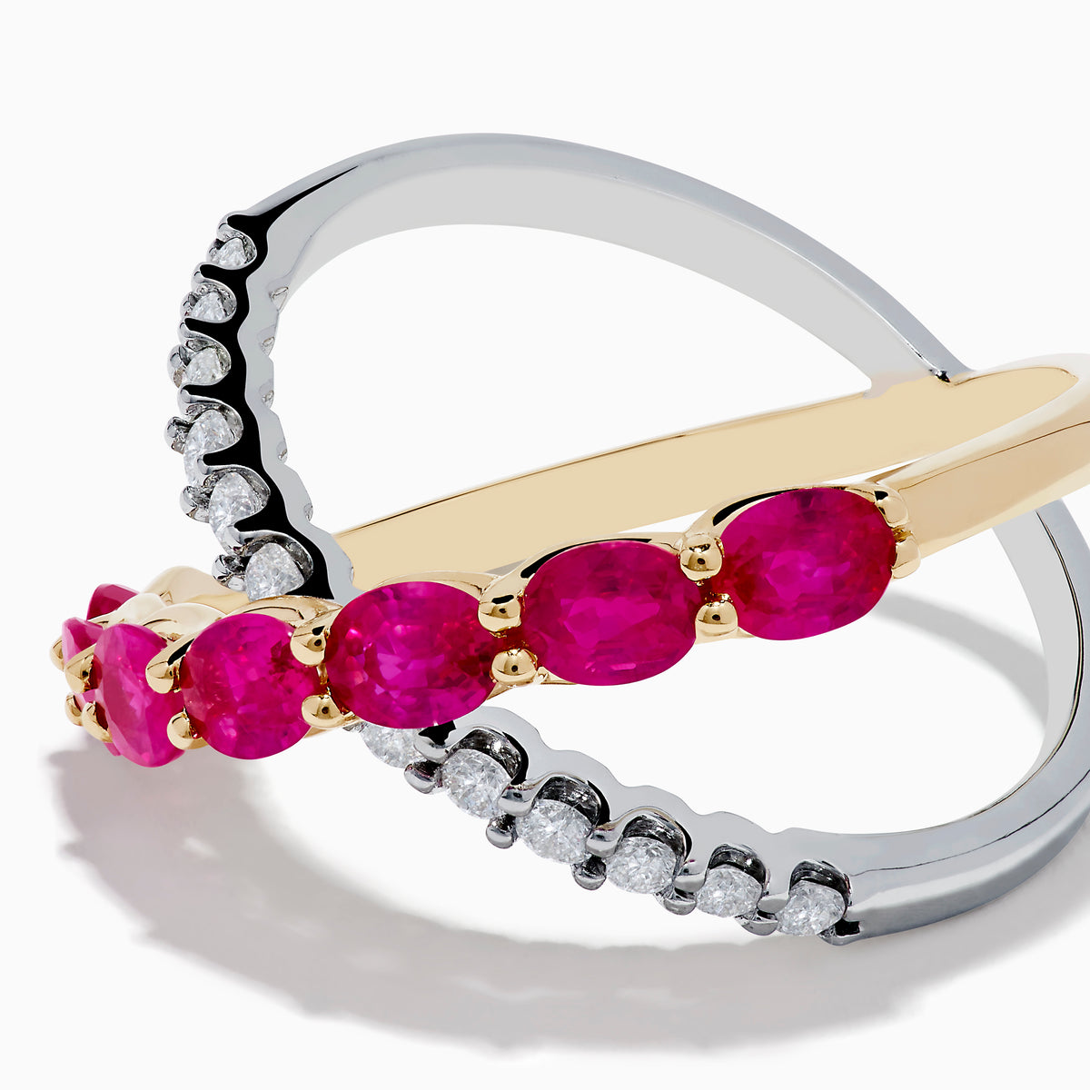 The 14K Two Tone Gold Ruby and Diamond Criss Cross Ring features intersecting gold and silver bands—one set with round diamonds, the other with oval rubies—for a strikingly elegant look.