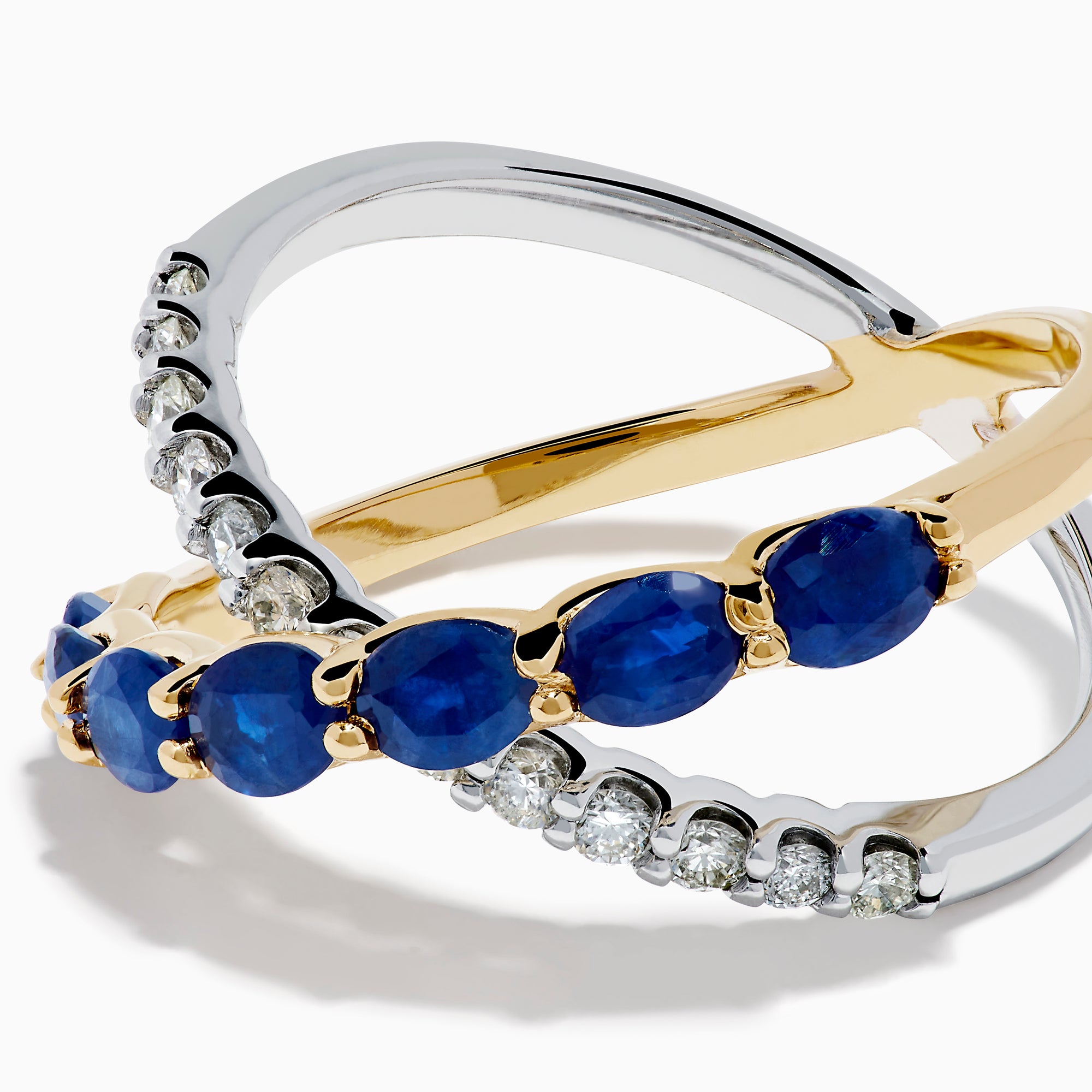 The Royale Bleu 14K Two Tone Gold Sapphire and Diamond Criss Cross Ring features alternating sapphires and clear diamonds, elegantly displayed against a white background.