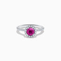 The 14K White Gold Pink Sapphire and Diamond Ring features a round pink sapphire center, a halo of diamonds, and additional diamonds along the band.