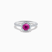 The 14K White Gold Pink Sapphire and Diamond Ring features a round pink sapphire center, a halo of diamonds, and additional diamonds along the band.