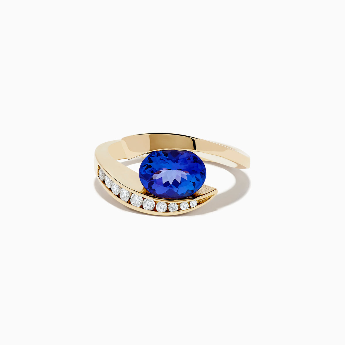 The Nahla Siri 14K Yellow Gold Tanzanite and Diamond Ring by Effy features a large oval tanzanite center stone, accented with a curved row of small round diamonds set along one side of the gold band.