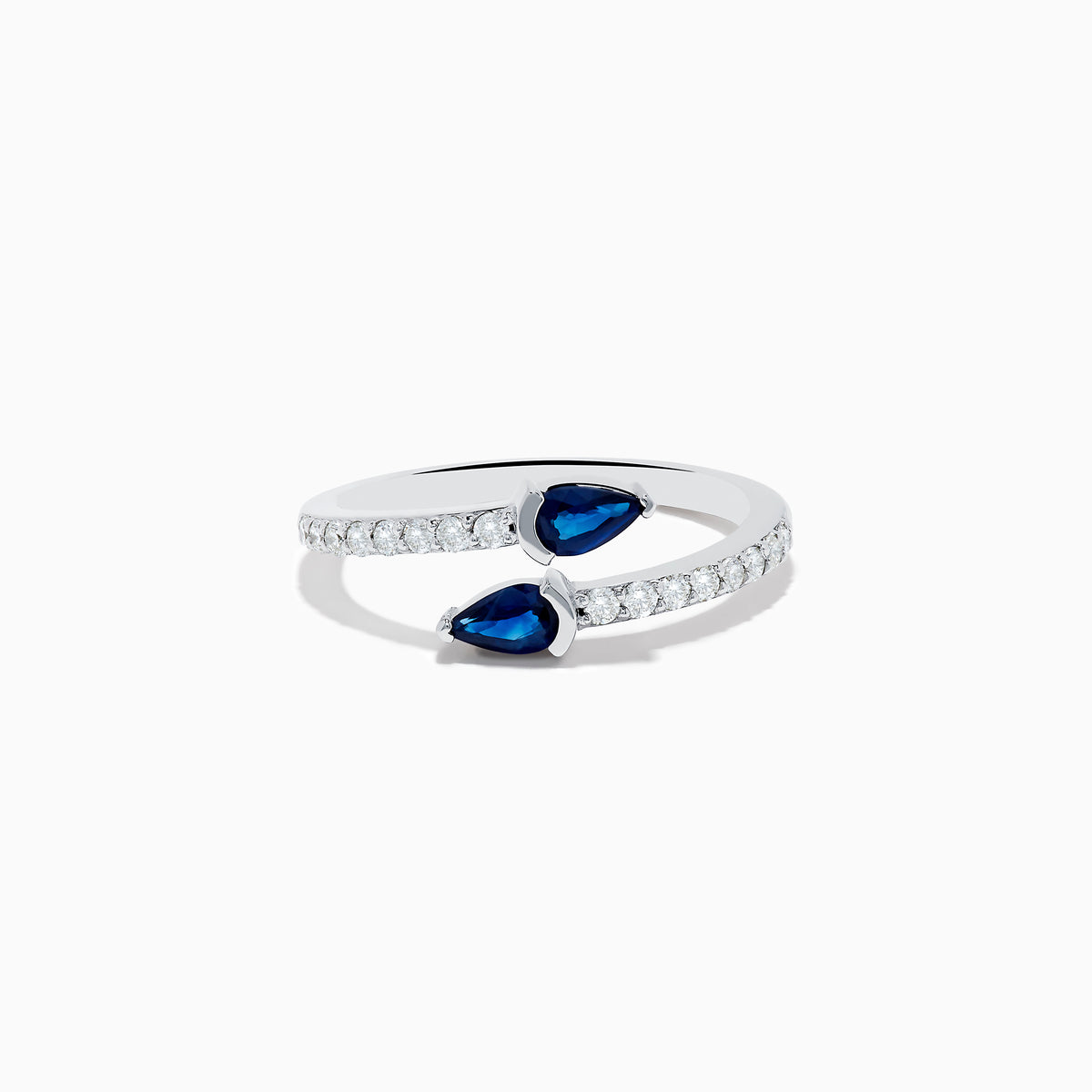 The Royal Bleu 14K White Gold Sapphire and Diamond Bypass Ring showcases two pear-shaped blue sapphires facing each other with a gap between them and a band accented by sparkling diamonds.