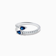 The Royal Bleu 14K White Gold Sapphire and Diamond Bypass Ring showcases two pear-shaped blue sapphires facing each other with a gap between them and a band accented by sparkling diamonds.