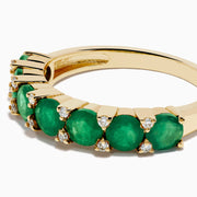 The 14K Yellow Gold Emerald and Diamond Band showcases oval green emeralds accented by small round white diamonds, beautifully displayed on a white background.