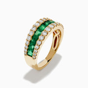 The Brasilica 14K Yellow Gold Emerald and Diamond Wide Band Ring features a symmetrical design with two rows of round diamonds framing horizontally set rectangular green emeralds, offering timeless sophistication.