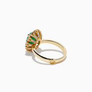 The 14K Yellow Gold Emerald and Diamond Ring showcases an oval emerald center accented by a halo of round white diamonds, displayed against a white background.