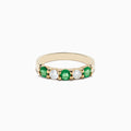 The Brasilica 14K Yellow Gold Emerald and Diamond Band Ring features alternating round emeralds and clear diamonds set in a row on the gold band.