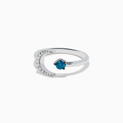 The Bella Bleu 14K White Gold White and Blue Diamond Crescent Moon Ring features a crescent moon with clear stones and an open band showcasing a round blue diamond opposite the moon.