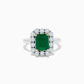 The Brasilica 14K Two-Tone Gold Emerald and Diamond Ring features a rectangular emerald, a halo of round diamonds, and silver band accented with gold prongs at each corner for a striking look.