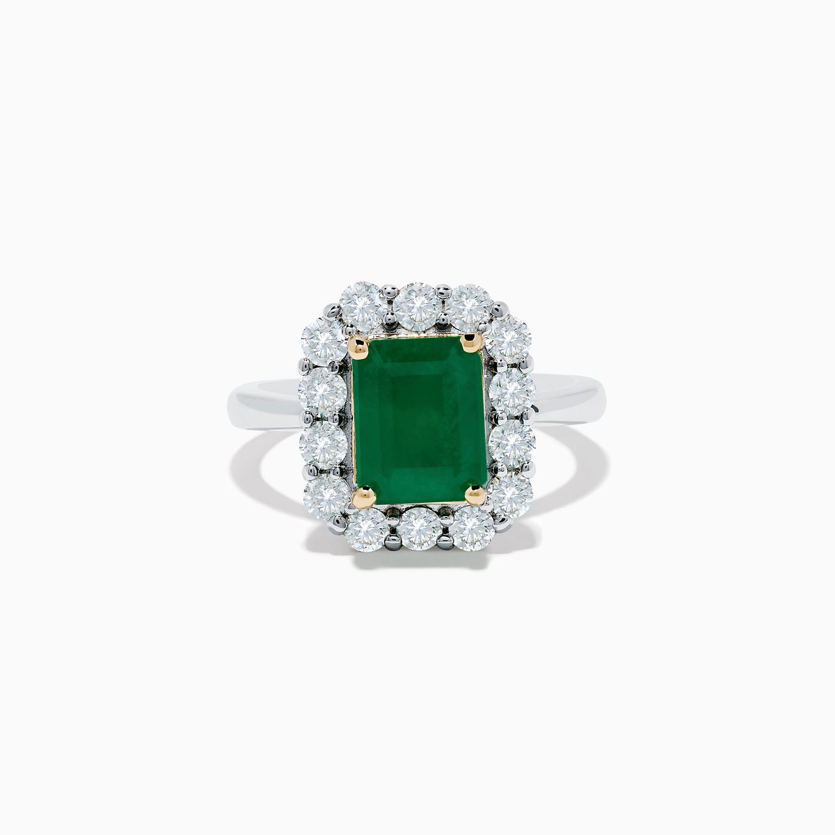 The Brasilica 14K Two-Tone Gold Emerald and Diamond Ring features a rectangular emerald, a halo of round diamonds, and silver band accented with gold prongs at each corner for a striking look.