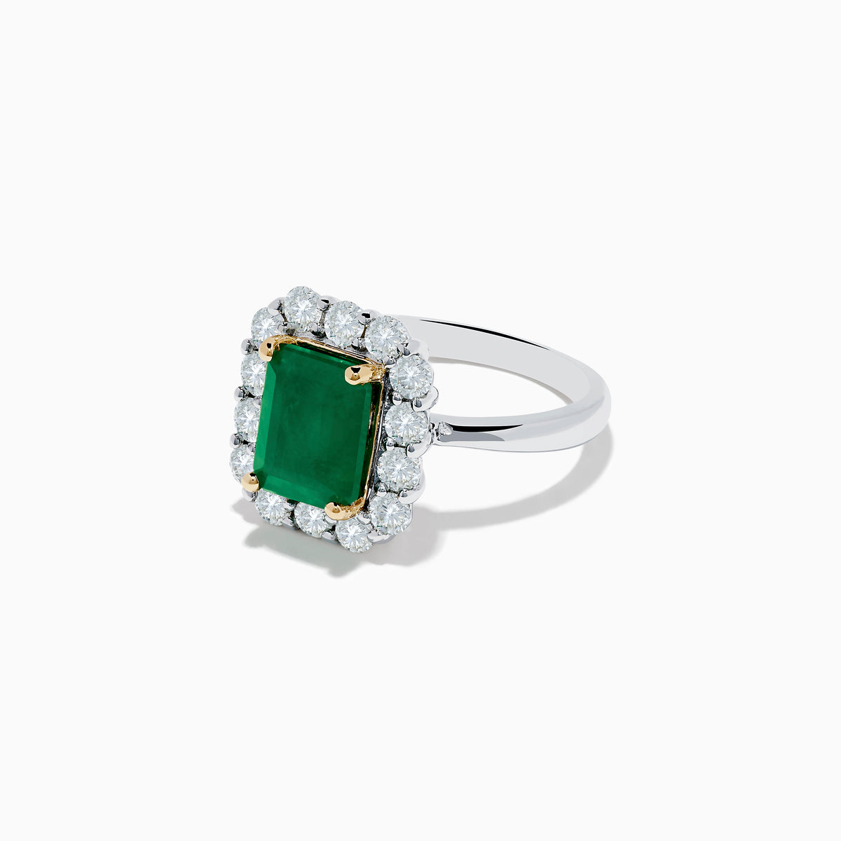 The Brasilica 14K Two-Tone Gold Emerald and Diamond Ring features a rectangular emerald, a halo of round diamonds, and silver band accented with gold prongs at each corner for a striking look.
