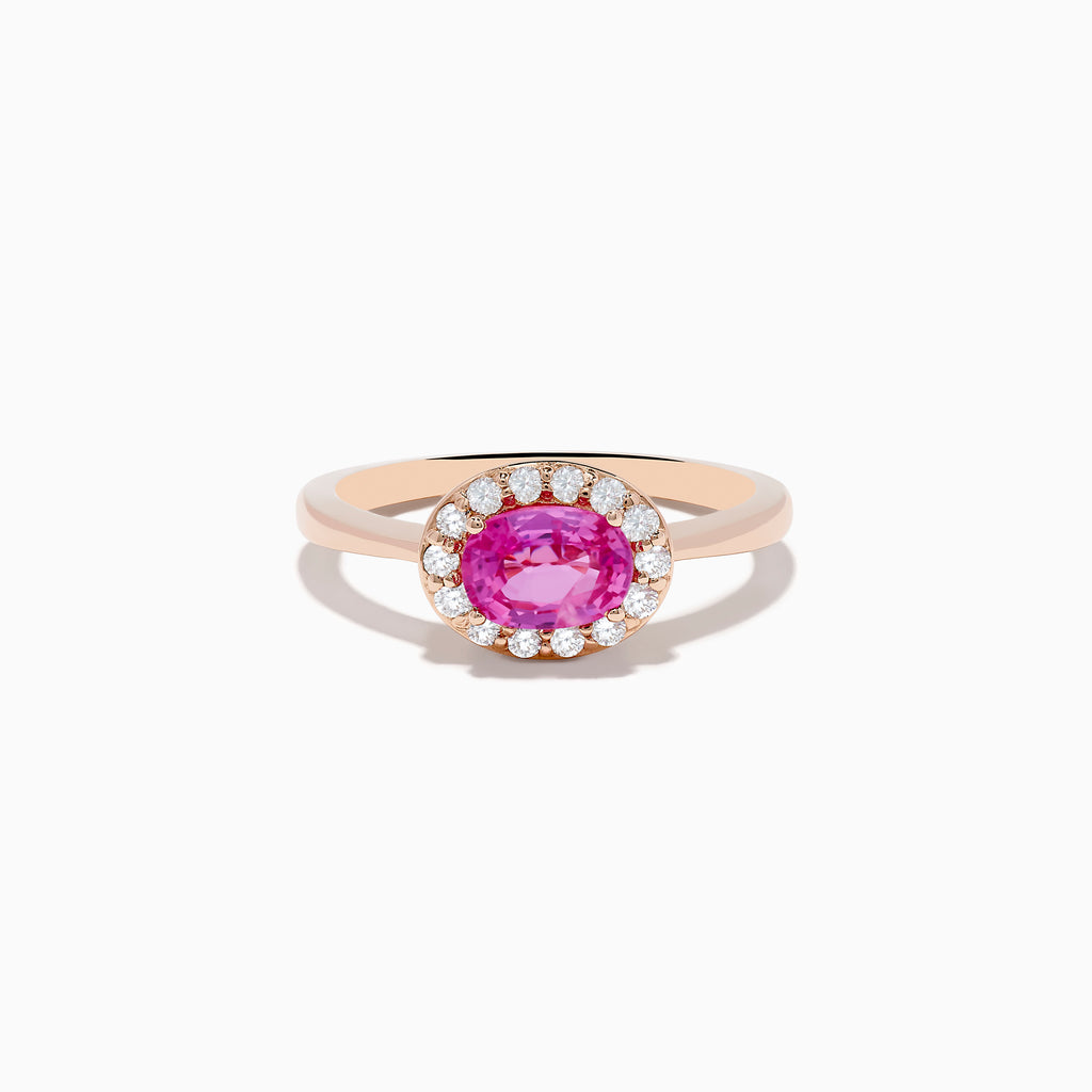 The 14K Rose Gold Pink Sapphire and Diamond Ring showcases an oval pink sapphire center, accented by a halo of round white diamonds, all set against a white background.