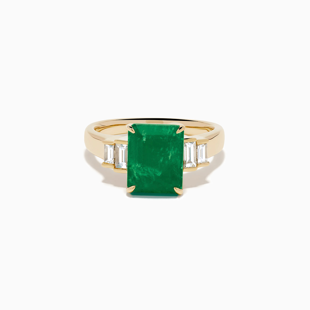 The 14K Yellow Gold Emerald and Diamond Solitaire Ring showcases a vibrant rectangular emerald at its center, accented by two baguette-cut diamonds on each side for a truly elegant look.
