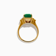 The 14K Yellow Gold Emerald and Diamond Solitaire Ring showcases a vibrant rectangular emerald at its center, accented by two baguette-cut diamonds on each side for a truly elegant look.