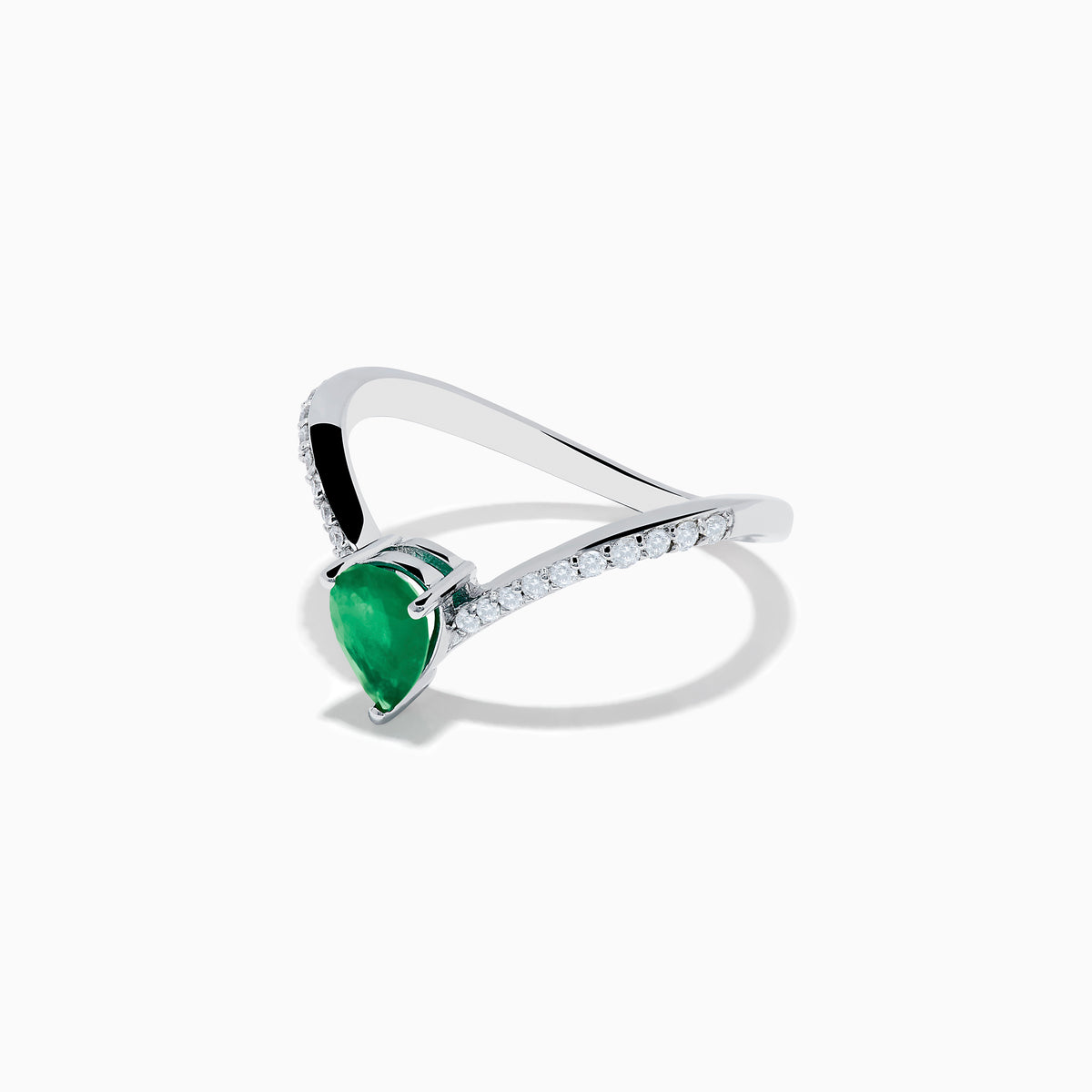The Brasilica 14K White Gold Emerald and Diamond Ring has a pear-shaped green emerald center and sparkling round diamonds on a V-shaped band, shown on a plain white background.