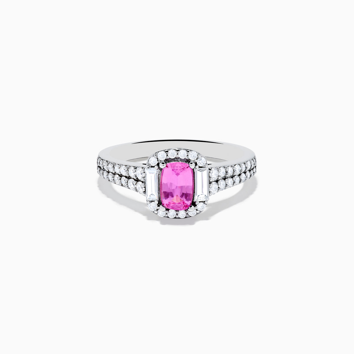 The 14K White Gold Pink Sapphire and Diamond Halo Ring showcases a vivid oval pink sapphire, encircled by a diamond halo with extra diamonds set along its elegant double band.