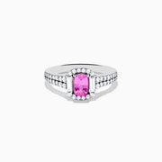 The 14K White Gold Pink Sapphire and Diamond Halo Ring showcases a vivid oval pink sapphire, encircled by a diamond halo with extra diamonds set along its elegant double band.