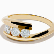 The D'Oro 14K Yellow Gold Diamond Bypass Ring features three round white diamonds in a row and a modern, open, curved band design, shown on a white background.