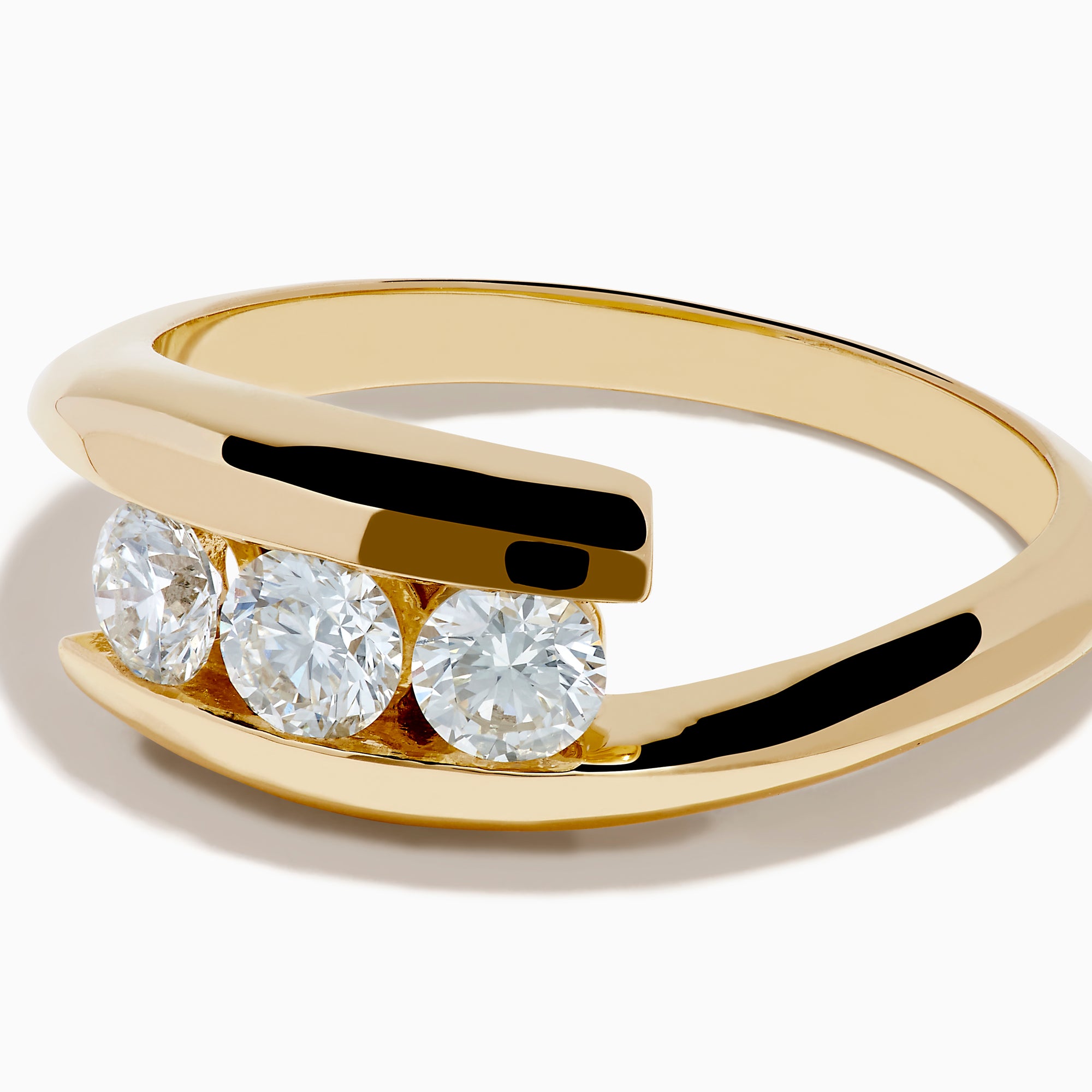 The D'Oro 14K Yellow Gold Diamond Bypass Ring features three round white diamonds in a row and a modern, open, curved band design, shown on a white background.