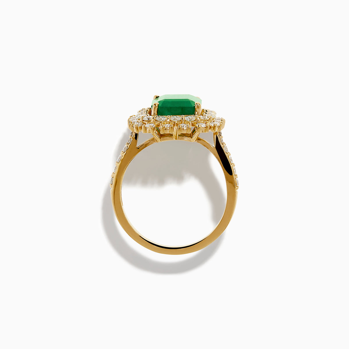The 14K Yellow Gold Emerald and Diamond Halo Cocktail Ring showcases a large rectangular green emerald at the center, surrounded by a sparkling double halo of round white diamonds.