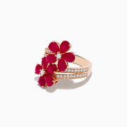 The Ruby Royale 14K Rose Gold Ruby and Diamond Floral Ring features two ruby flower motifs with diamond centers and a diamond-accented band, displayed on a white background.