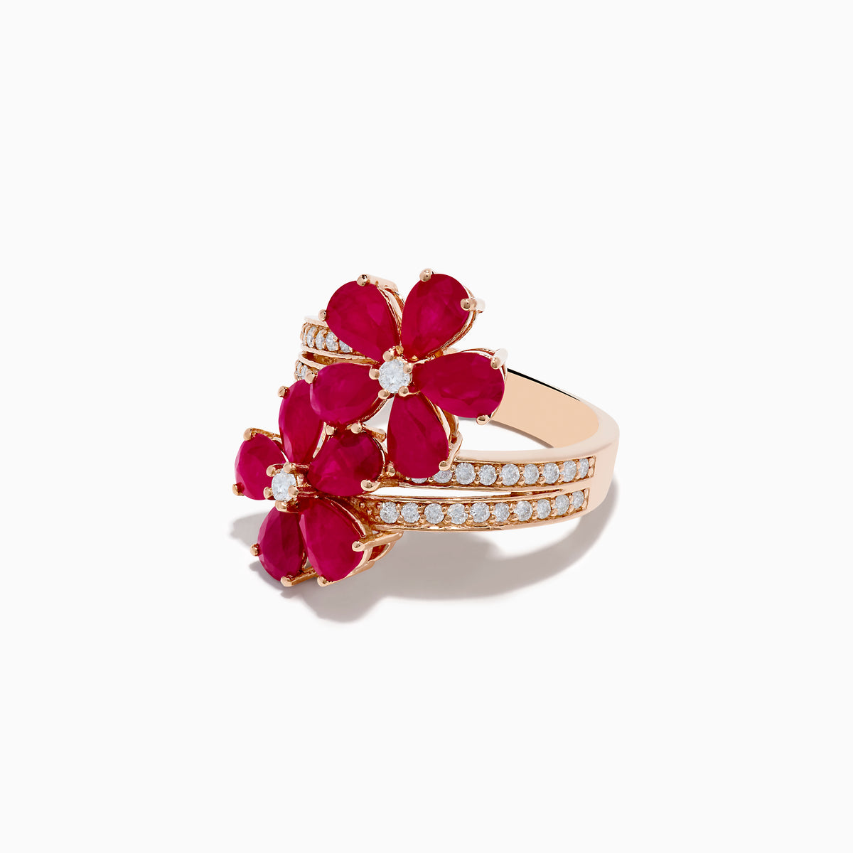 The Ruby Royale 14K Rose Gold Ruby and Diamond Floral Ring features two ruby flower motifs with diamond centers and a diamond-accented band, displayed on a white background.