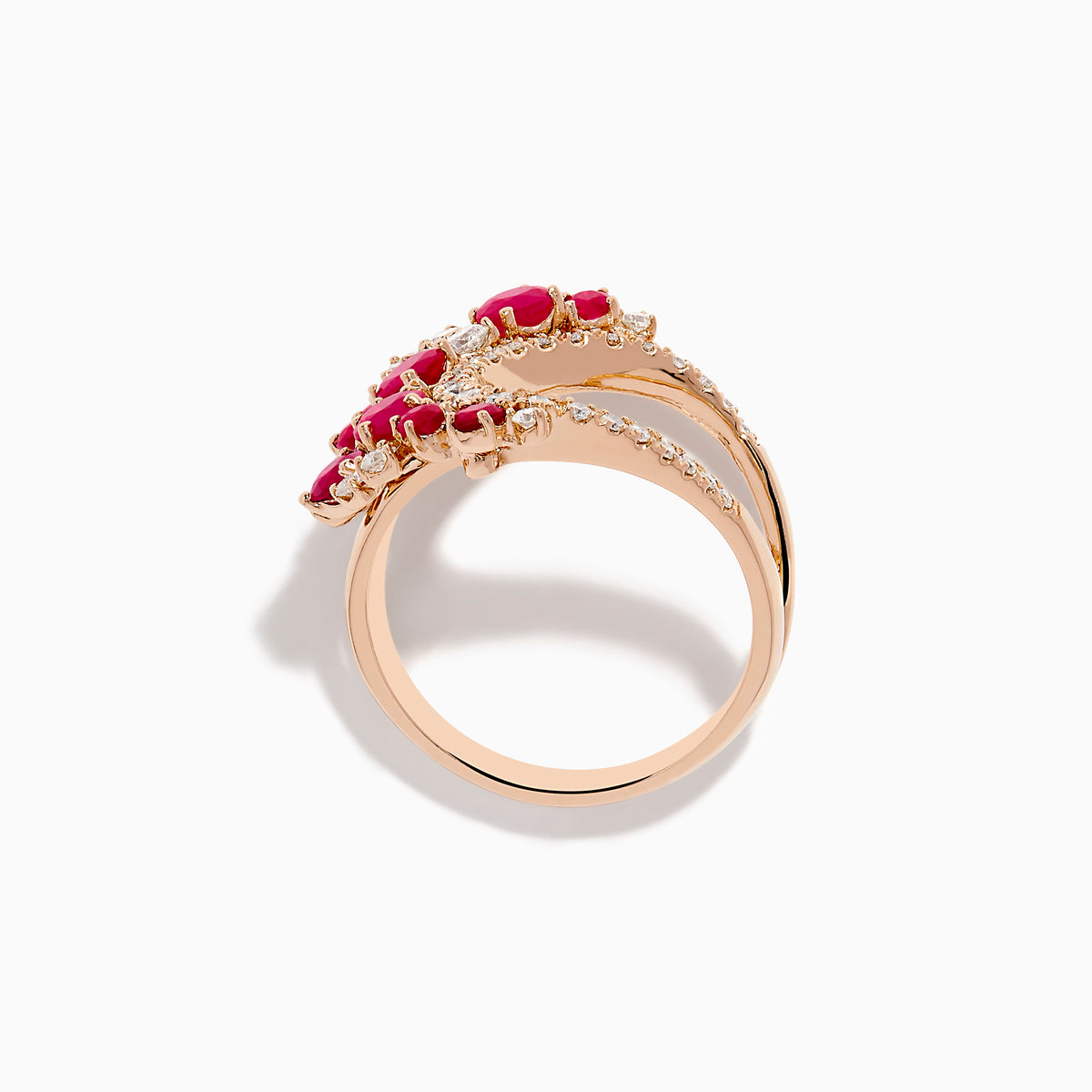 The Ruby Royale 14K Rose Gold Ruby and Diamond Wave Ring features a heart-shaped open design with clusters of round red rubies and sparkling white diamonds set along the band in elegant floral patterns.