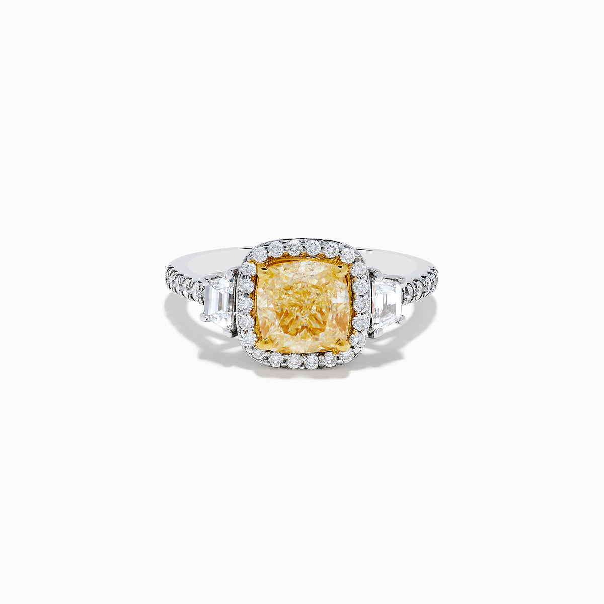 The Canare 18K Two Tone Gold White and Yellow Diamond Ring features a cushion-cut yellow diamond center, framed by a halo of white diamonds and more diamonds set along the band in elegant white gold.