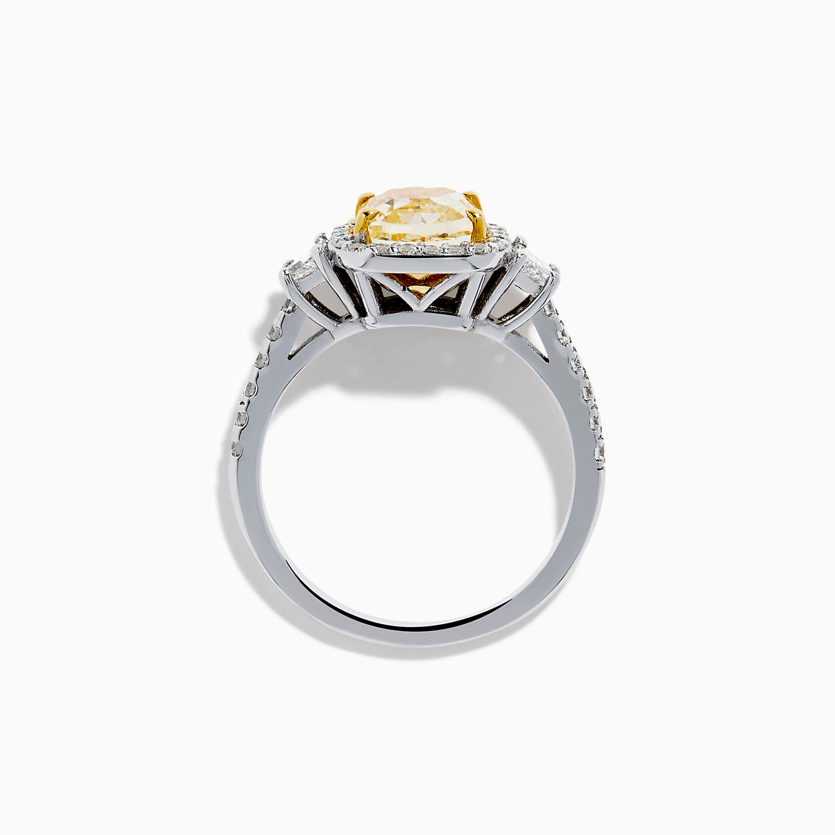The Canare 18K Two Tone Gold White and Yellow Diamond Ring features a cushion-cut yellow diamond center, framed by a halo of white diamonds and more diamonds set along the band in elegant white gold.