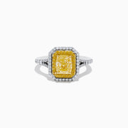 The Canare` 18K Two Tone Gold Yellow and White Diamond Ring features a radiant-cut yellow diamond center, framed by a double halo of white and yellow diamonds on a two-tone gold band.