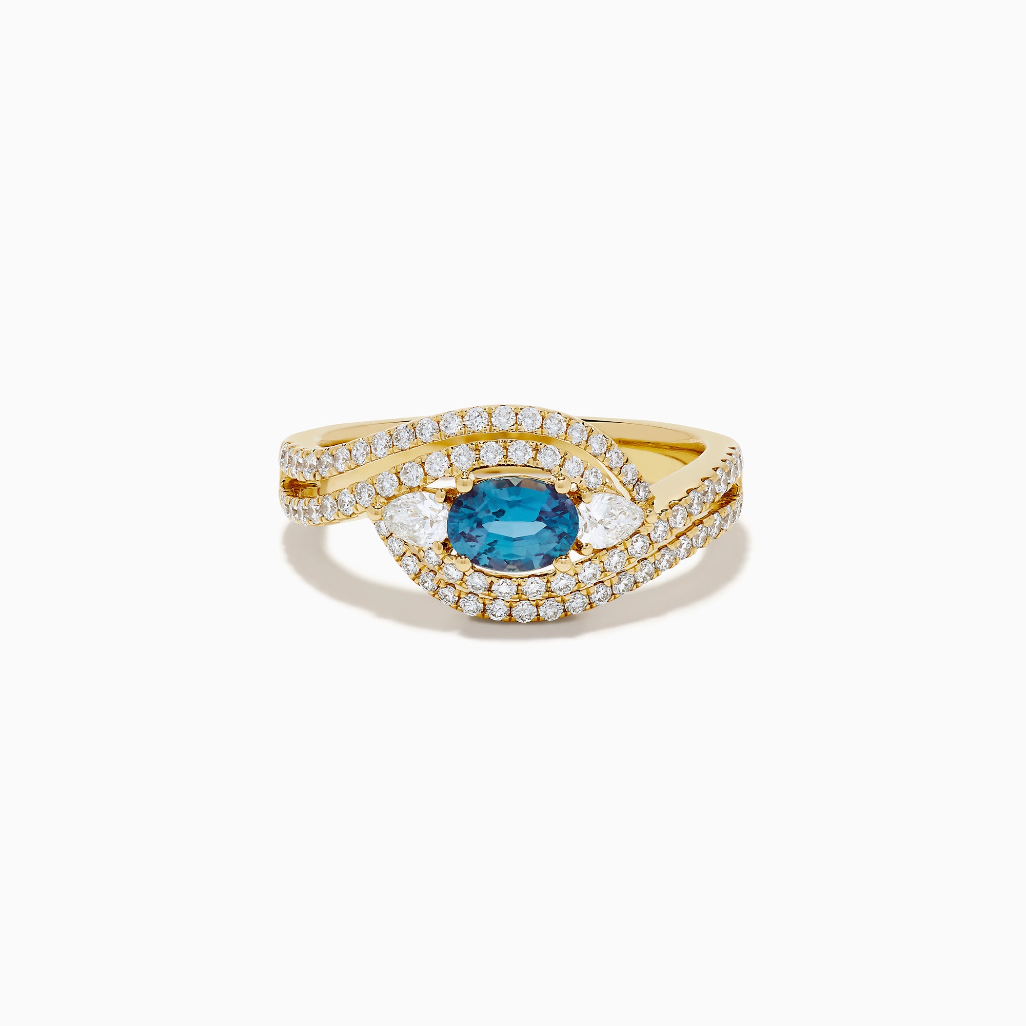 The 18K Yellow Gold Alexandrite and Diamond Swirl Halo Ring features a central oval blue alexandrite, two marquise-cut diamonds, and rows of small round diamonds in an eye-shaped swirl design.