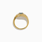 The 18K Yellow Gold Alexandrite and Diamond Swirl Halo Ring features a central oval blue alexandrite, two marquise-cut diamonds, and rows of small round diamonds in an eye-shaped swirl design.