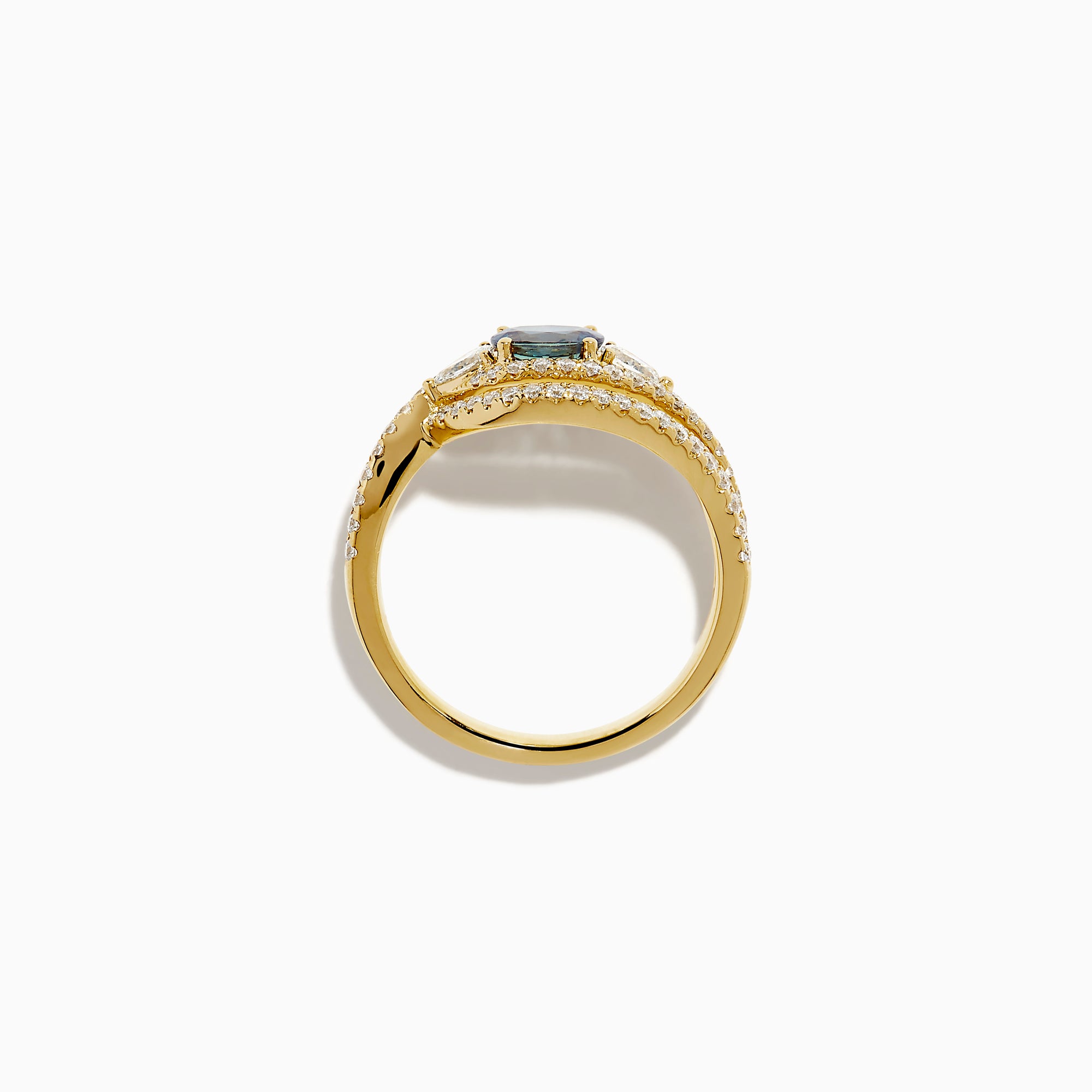 The 18K Yellow Gold Alexandrite and Diamond Swirl Halo Ring features a central oval blue alexandrite, two marquise-cut diamonds, and rows of small round diamonds in an eye-shaped swirl design.