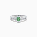 The 18K White Gold Alexandrite and Diamond Split Halo Ring showcases a central oval green Alexandrite, surrounded by a diamond halo with additional diamonds set along the band.